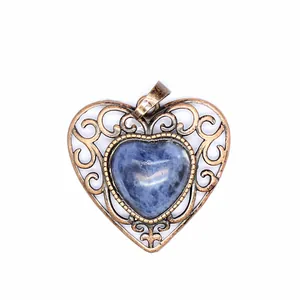 Macro view of a vintage heart-shaped pendant with blue natural stone inlay