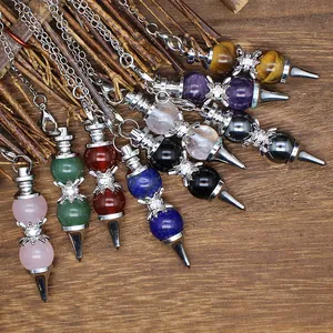 Macro detail of various natural gemstone ball pendulum pendants on wood background
