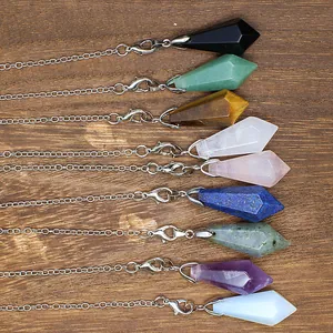 Selection of colorful hexagonal natural stone pendulum pendants on a wood surface