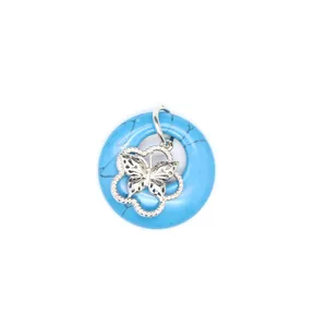 Gros plan d'un pendentif en pierre naturelle bleue avec breloque papillon en argent.