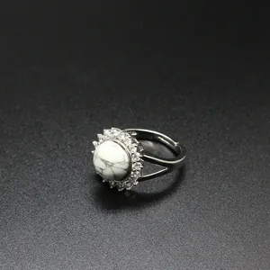 Close-up of a silver-toned adjustable ring featuring a marbled white stone and zircon halo.