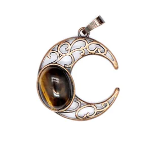 Close-up of antique hollow crescent moon pendant featuring oval tiger eye stone detail