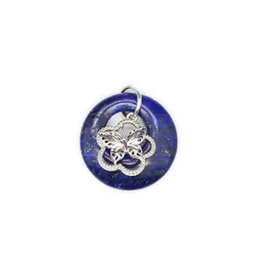Vue détaillée d'un pendentif donut en lapis-lazuli bleu avec un papillon argenté