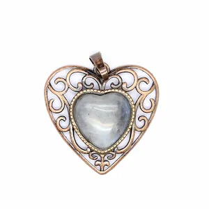 Close-up detail of a vintage bronze hollow heart pendant with a natural stone center