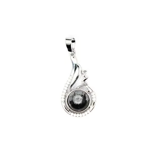 Close-up of a silver-toned pendant featuring a round natural black gemstone and crystals