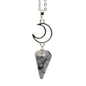 Detailed macro shot of a silver crescent moon pendant with a hexagonal snowflake obsidian stone.