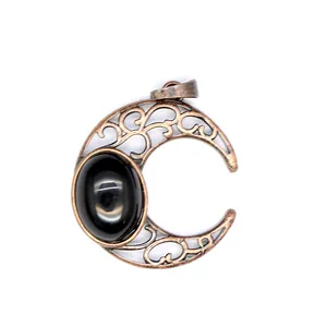Detail shot of an antique bronze crescent moon pendant featuring a black natural stone