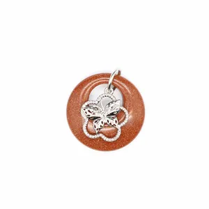 Vue détaillée d'un pendentif papillon en pierre de sable doré sur fond blanc