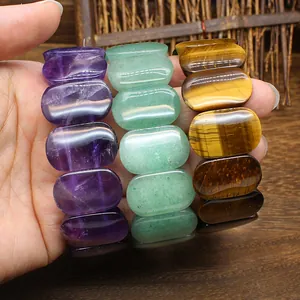 Close-up of polished natural gemstone bracelets in amethyst, aventurine, and tiger eye