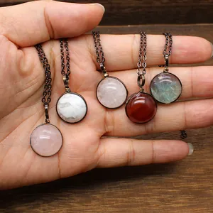 Hand holding variety of vintage natural stone pendant necklaces with bronze chains