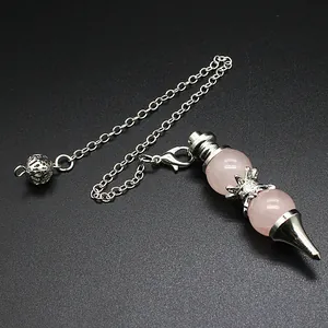 Detailed view of rose quartz dowsing pendulum with silver chain on black surface