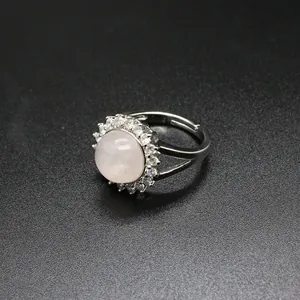 Close-up of a silver adjustable ring with a round pink quartz stone and micro-CZ border