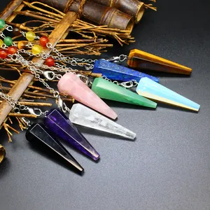 Close-up of seven chakra natural stone hexagonal cone pendulums on dark textured surface.