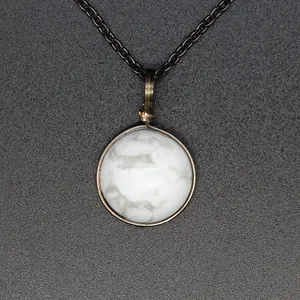 Close-up detail of a minimalist vintage necklace with round white natural stone pendant