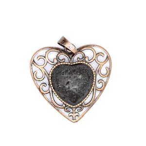 Detailed view of a vintage hollowed heart pendant featuring a textured natural lava stone.
