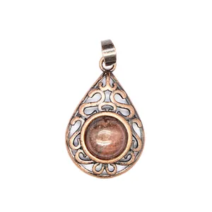 Detailed view of teardrop pendant with red aventurine stone and antique hollow metalwork