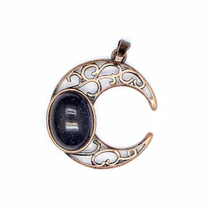 Macro view of antique bronze crescent moon pendant with blue goldstone cabochon