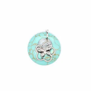 Détail macro d'un pendentif en pierre turquoise avec un papillon en argent ajouré