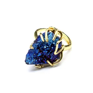 Macro view of blue druzy agate crystal ring with gold plated multi-claw setting.