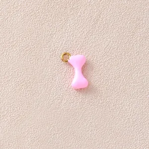 Detailansicht eines rosa emaillierten Knochenanhängers mit vergoldetem Ring für DIY-Schmuck