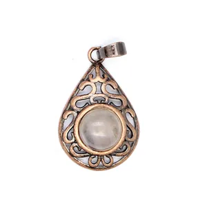 Detail view of a vintage bronze hollow teardrop pendant with a natural stone