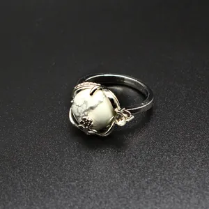 Gros plan d'une bague vintage avec une pierre blanche marbrée et des détails de fleurs en cristal