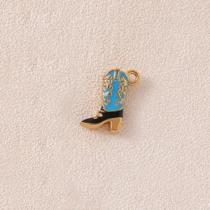 Close-up detail of blue and black enamel cowboy boot charm with intricate gold patterns