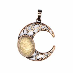 Close-up of a vintage bronze hollow moon pendant featuring a spotted natural stone inlay