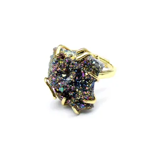 Macro detail of iridescent plated natural agate druzy stone on a gold ring setting