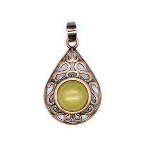 Vintage hollow teardrop pendant with central greenish-yellow gemstone in copper finish.