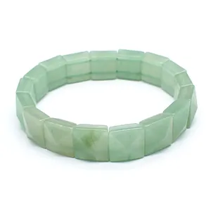 Close-up view of faceted square green natural stone beads on a stretch elastic bracelet