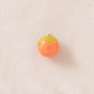 Detailed macro view of a 3D persimmon fruit pendant for DIY jewelry and crafts.