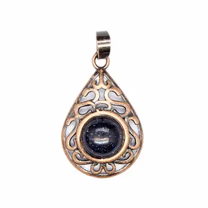 Close-up detail of a vintage teardrop pendant with blue sandstone and antique copper filigree