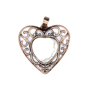 Vintage bronze hollow filigree heart pendant with white natural stone inlay detail view