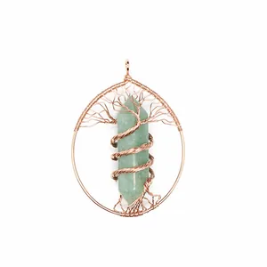 Macro view of a handmade tree of life pendant featuring a green hexagonal crystal pillar