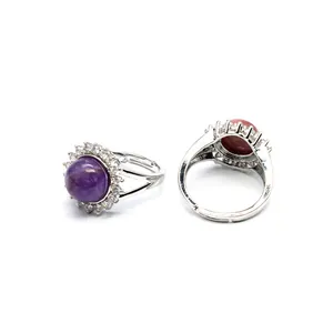 Close-up detail of adjustable silver rings with purple and red round stones and halo crystals
