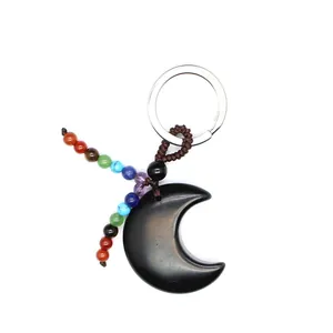 Nahaufnahme eines Mond-Schlüsselanhängers aus Naturstein mit bunten Chakra-Perlen.