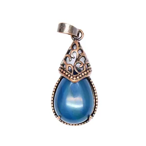 Close-up detail of a vintage teardrop pendant featuring a blue natural stone and filigree