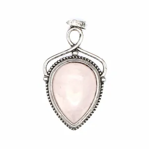 Primer plano de un colgante de cuarzo rosa natural en forma de gota con marco plateado