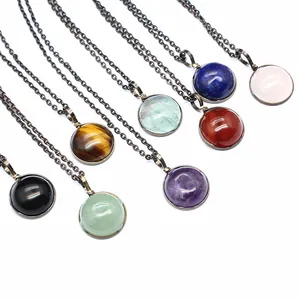 Close-up of diverse natural stone necklaces with vintage bronze chains and round pendants.