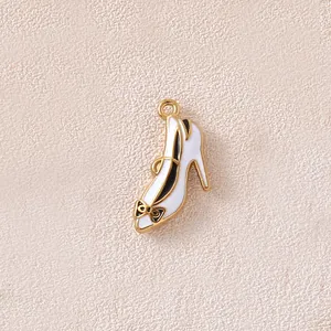 Close-up detail of a white enamel high heel shoe pendant with golden bow for DIY jewelry