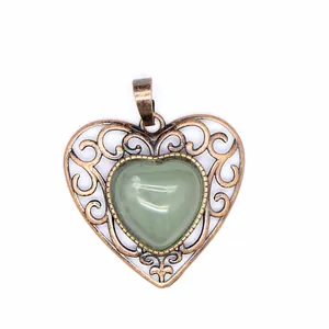 Detailed macro view of vintage hollow heart pendant with green natural stone inlay