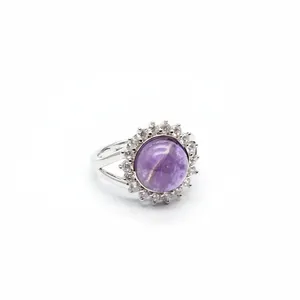 Detailed shot of a silver ring featuring a round purple amethyst stone and CZ halo.