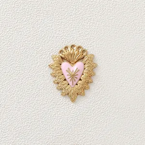 Dettaglio ravvicinato di un ciondolo a cuore vintage in acciaio dorato con smalto rosa