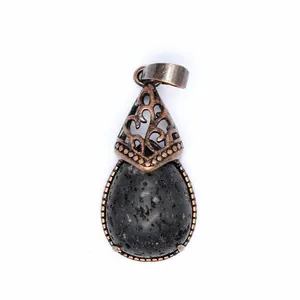 Close-up of vintage teardrop-shaped pendant featuring black lava stone and filigree