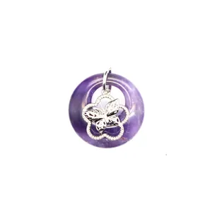 Détail macro du pendentif beignet en améthyste violette avec papillon en argent