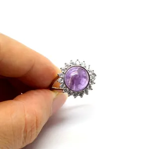 Detail of an adjustable silver ring with a round purple crystal and CZ halo.