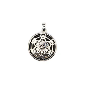 Detailopname van holle Metatron-kubus hanger met zwarte natuursteen inlegwerk.
