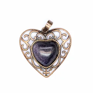 Detailed macro view of a vintage bronze hollow heart pendant with blue sandstone.