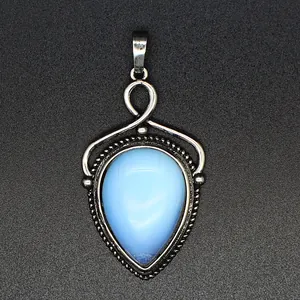 Primer plano de un colgante de piedra azul en forma de gota con detalles de metal plateado.